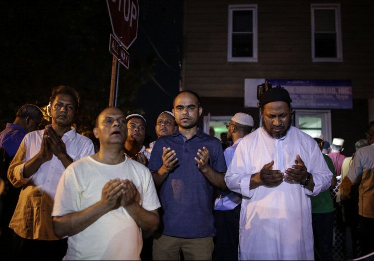 Community members pray outside the Al-Furqan Jame Mosque in Ozone Park after imam Maulama Akonjee and friend Thara Uddin were killed in the Queens borough of New York City