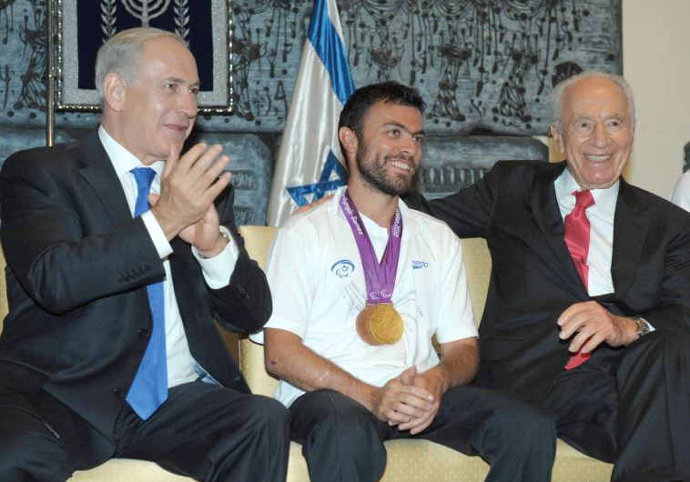 PRIME MINISTER Benjamin Netanyahu and then-president Shimon Peres welcome home gold medalist in tennis Noam Gershoni after the 2012 London Summer Paralympics.