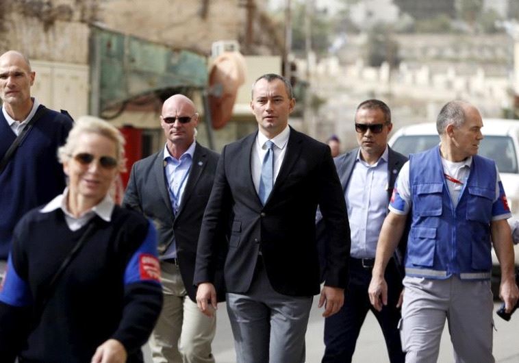 Nickolay Mladenov (C), the United Nations Secretary-General Special Representative to the Middle East, looks at Israeli soldiers during his visit to the West Bank city of Hebron November 4, 2015.