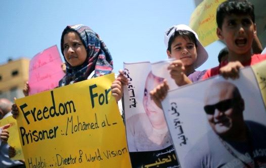 Palestinian demonstrators take part in a protest in solidarity with Mohammad El Halabi, World Vision's manager of operations in Gaza who was accused by Israel of funnelling millions of dollars in aid money to Hamas, organised by foundations and societies benefiting from World Vision in Gaza City Aug