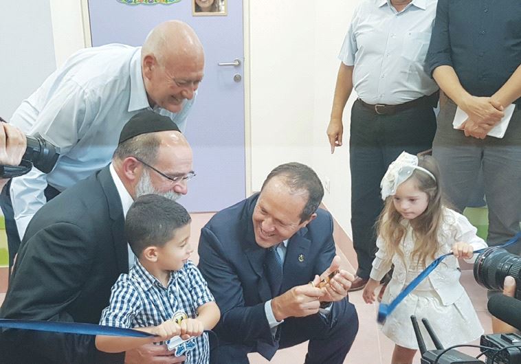 ERUSALEM MAYOR Nir Barkat (right) joins Shalva founder Rabbi Kalman Samuels and two children in cutting the ribbon for the kindergarten at the organization’s new complex in Jerusalem’s Beit Hakerem neighborhood.