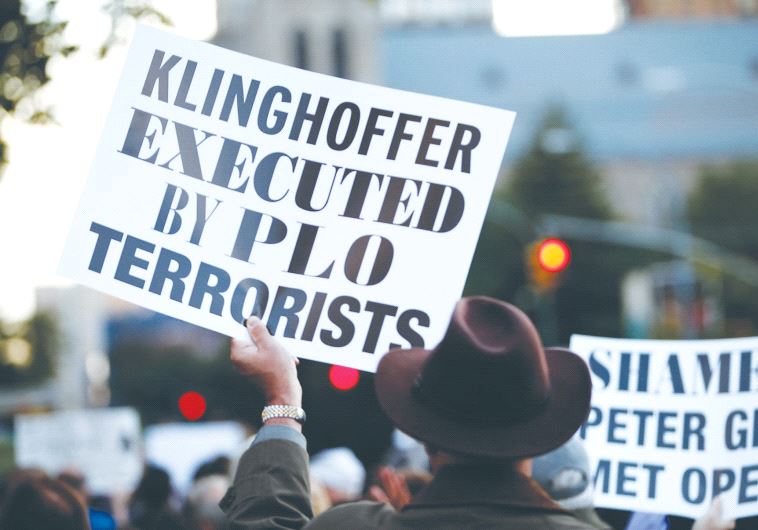 A PROTESTER holds up a sign condemning the Palestine Liberation Organization for the murder of Leon Klinghoffer