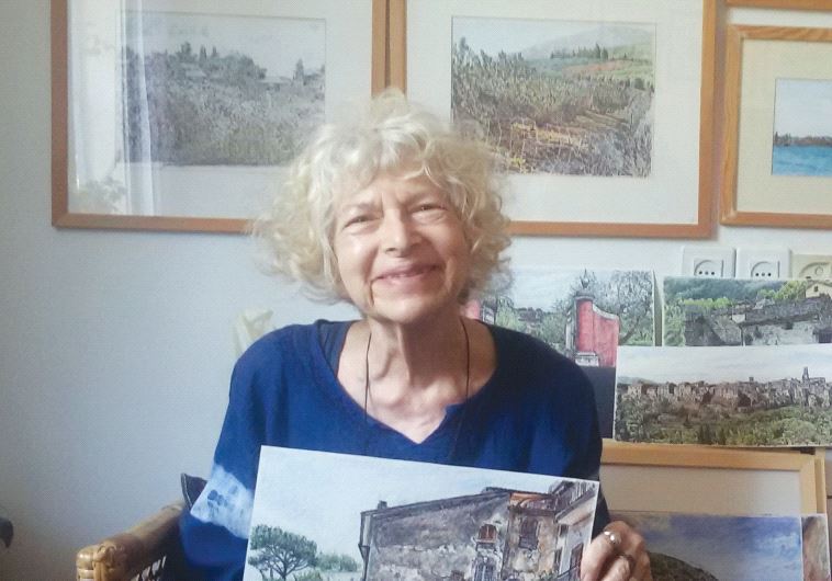 Helen Bar-Lev with her paintings. The unframed pictures are from her recent visit to Italy, while the framed ones depict the Israeli landscape