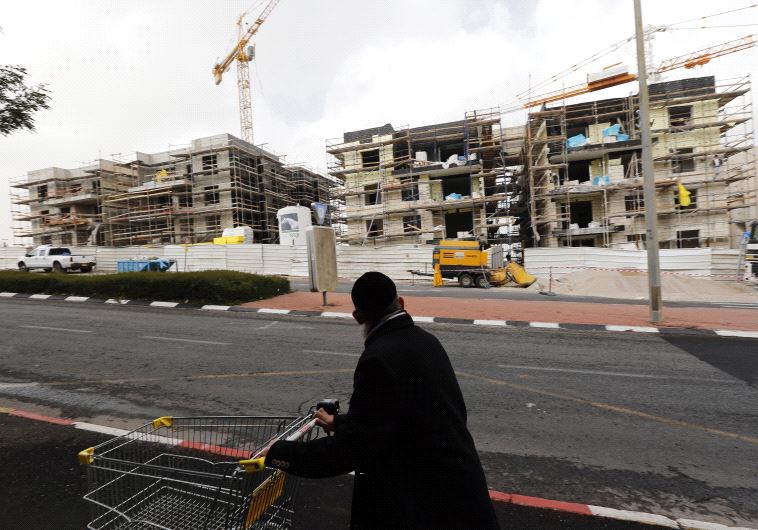 An ultra-Orthodox Jewish man pushes a shopping cart past a construction site in Gilo, in December 2012