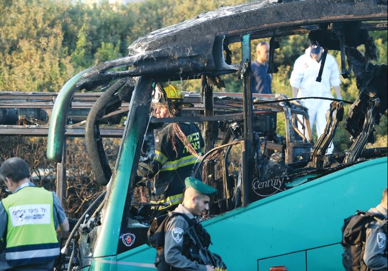 Border policemen and firefighters stand near a bus that was bombed in a terrorist attack in Jerusalem in April