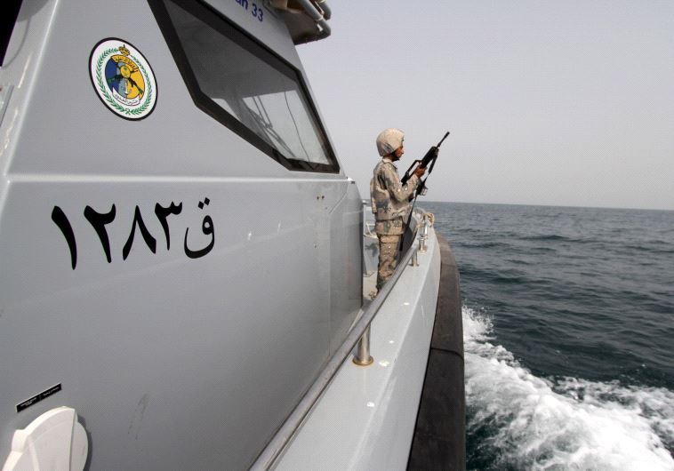 A Saudi border guard watches as he stands in a boat off the coast of the Red Sea on Saudi Arabia's maritime border with Yemen, near Jizan April 8, 2015.