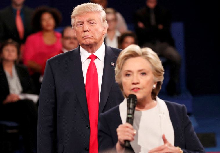 Republican US presidential nominee Donald Trump listens as Democratic nominee Hillary Clinton answers a question from the audience during their presidential town hall debate at Washington University in St. Louis, Missouri, US, October 9, 2016
