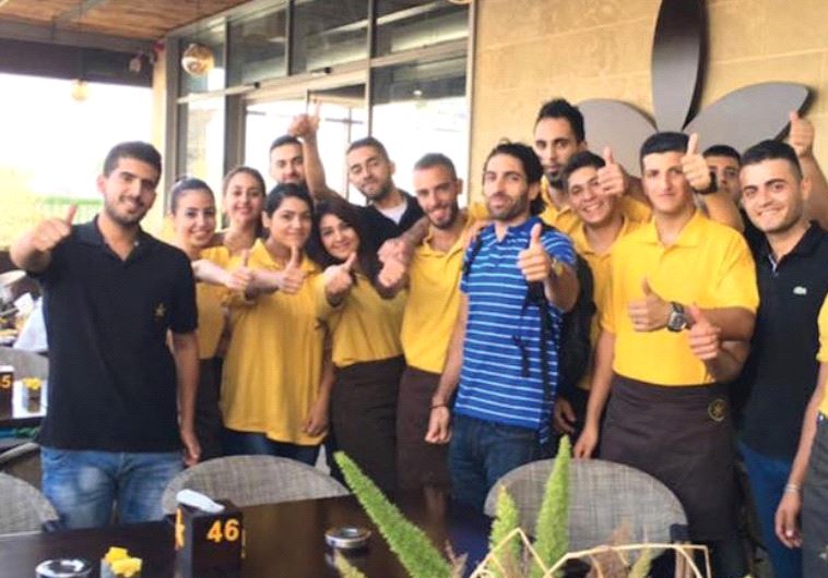 OWNER JOHN SAADEN posing with members of his staff outside Jasmine Cafe in Nablus.