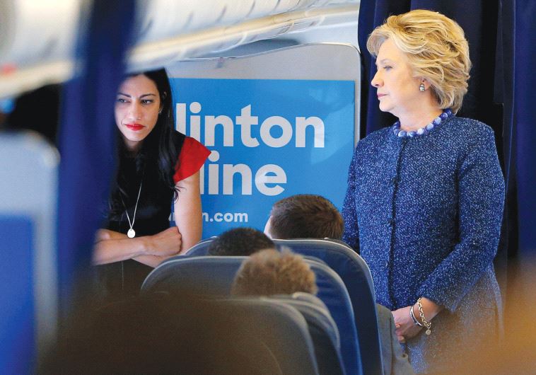 Hillary Clinton talks to staff members, including aide Huma Abedin (left), on her campaign plane before takeoff from White Plains, New York
