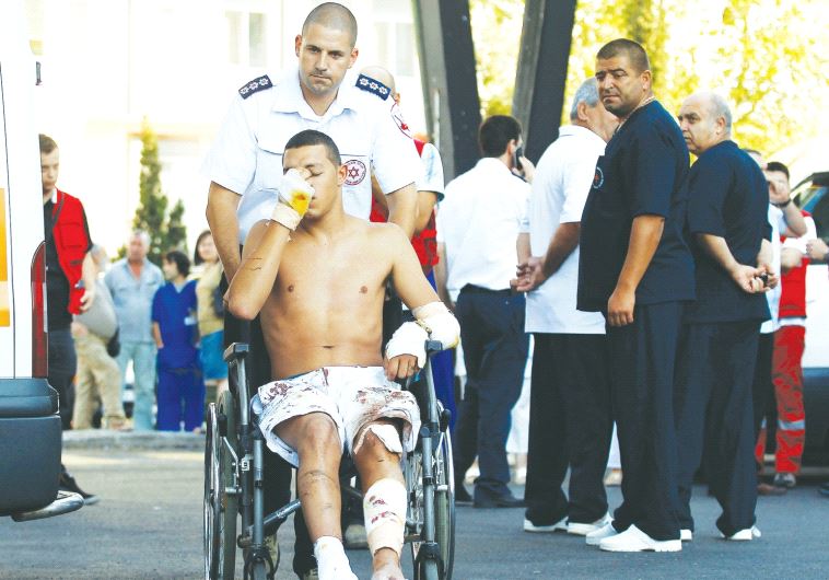AN ISRAELI SURVIVOR of the Hezbollah bombing at Burgas, Bulgaria, on July 19, 2012, is wheeled to a waiting ambulance as he leaves the hospital.