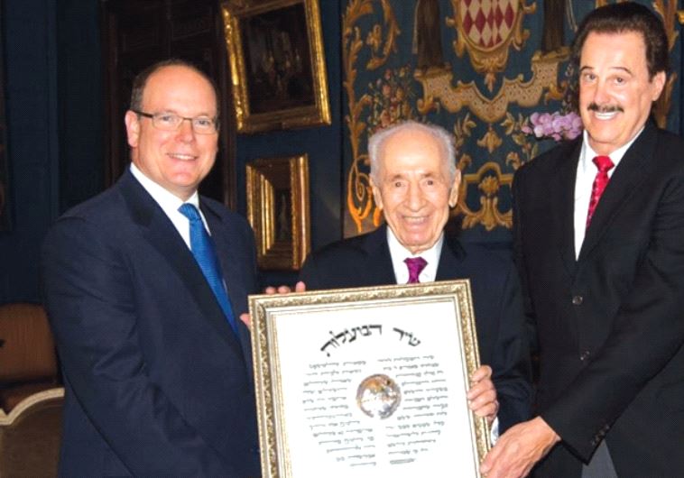 Mike Evans, right, presents an award to Prince Albert II of Monaco and Shimon Peres