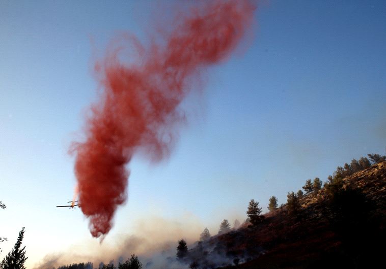 A firefighting plane drops fire retardant during a wildfire, near the communal settlement of Nataf, close to Jerusalem November 23, 2016. 