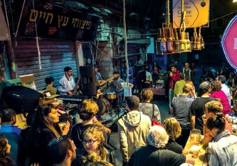 PATRONS CONVERGE on the Beer Bazaar in the Mahaneh Yehuda market, also known as the shuk, in downtown Jerusalem