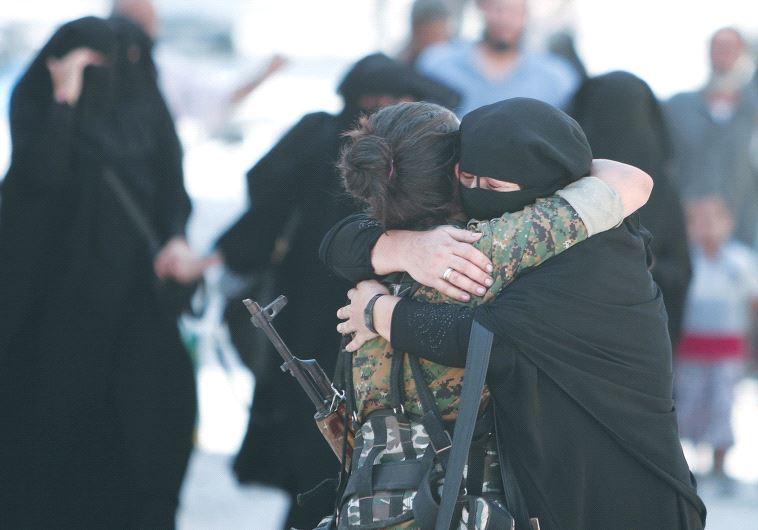 A WOMAN embraces a Syrian Democratic Forces fighter after being liberated from Islamic State control in the Syrian town of Manbij.