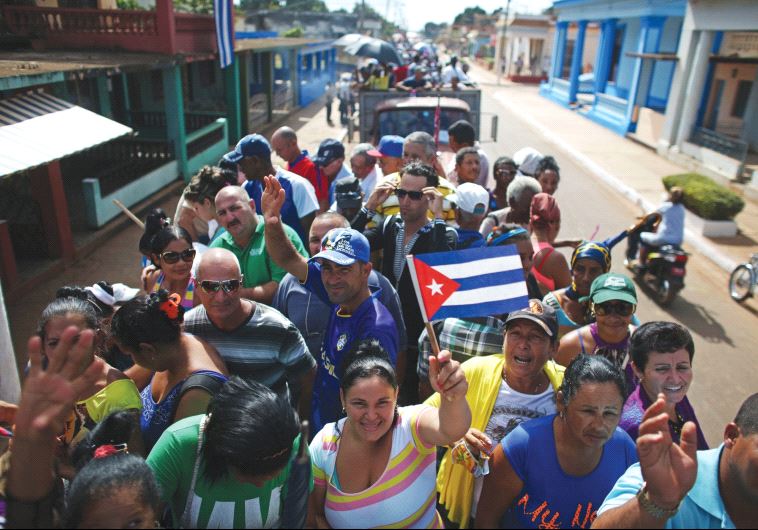 PEOPLE ARE transported to greet the caravan carrying the ashes of Fidel Castro in Colon, Cuba, on Wednesday.