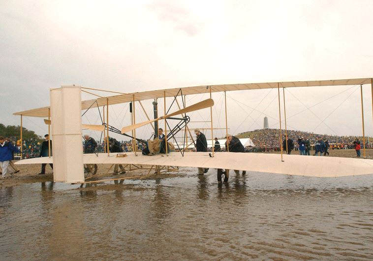 THE WRIGHT EXPERIENCE team rolls a Wright 1903 Flyer replica onto the field at the Wright Brothers National Memorial in Kill Devil Hills, North Carolina.
