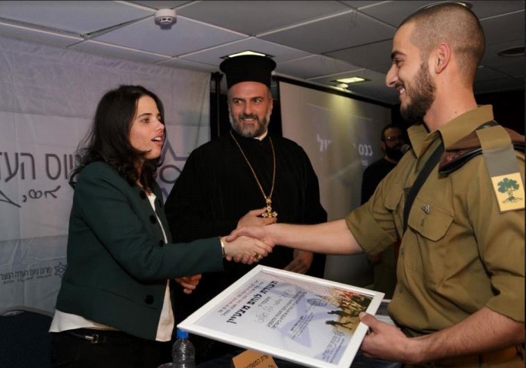 Caption: Justice Minister Ayelet Shaked and Father Gabriel Naddaf hand out an award to a Christian soldier
