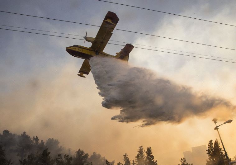 An Israeli firefighter plane helps extinguish a fire in the northern Israeli port city of Haifa on November 24, 2016