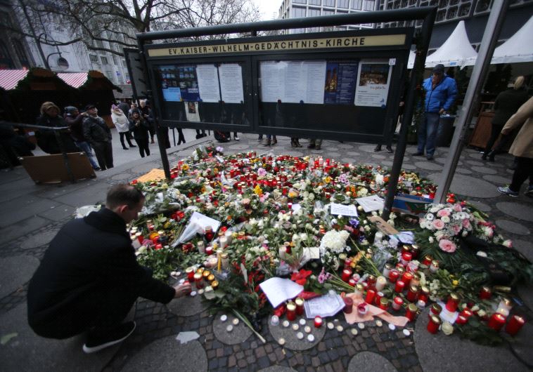 Flowers and candles are placed near the Christmas market in Berlin, Germany