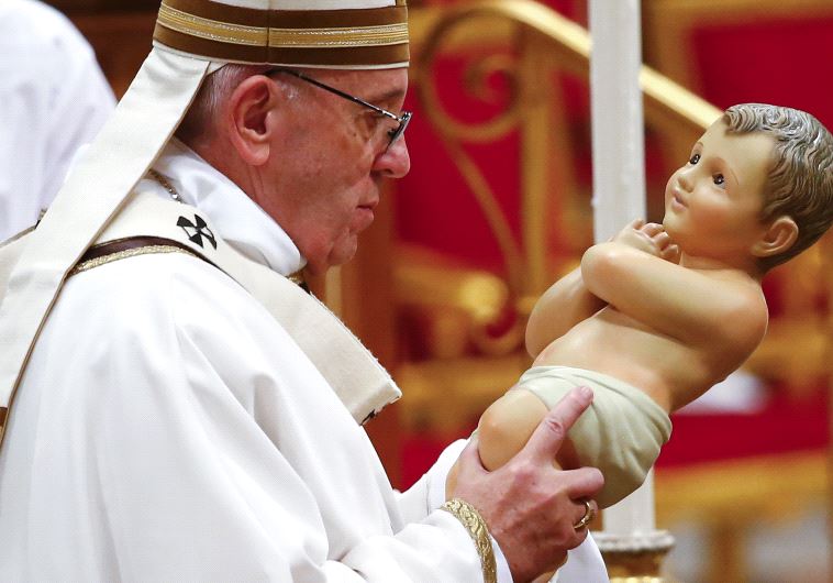 Pope Francis holds a statue of baby Jesus during the Christmas night Mass in Saint Peter's Basilica at the Vatican December 24, 2016