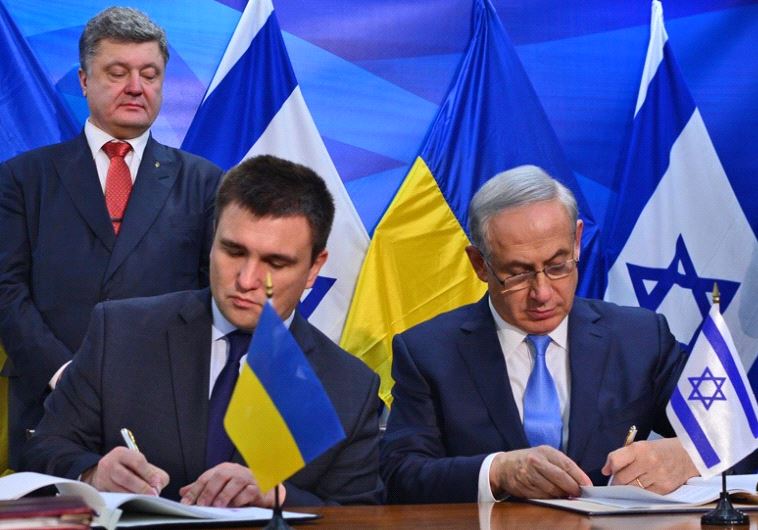 Prime Minister Benjmain Netanyahu and Ukrainian Foreign Minister Pavlo Klimkin sign agreeements as Ukrainian President Petro Poroshenko looks on