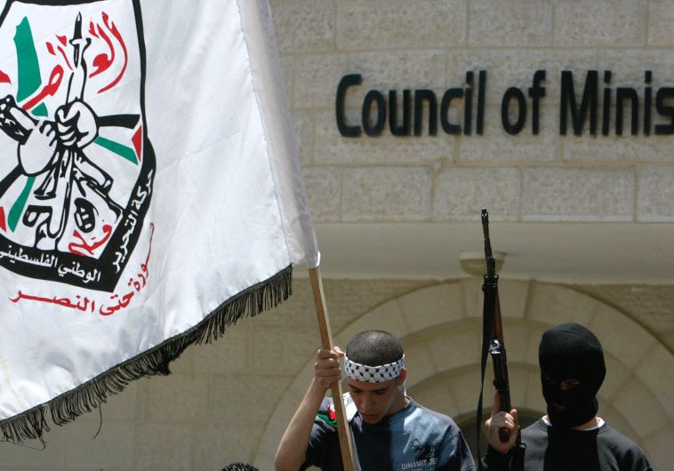 A MEMBER of the Aqsa Martyrs Brigades waves a flag in Ramallah in 2007. 