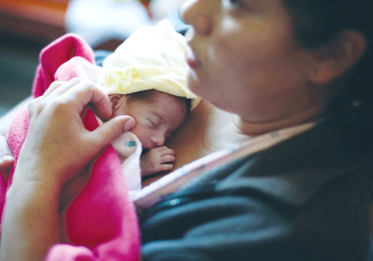 A MOTHER hugs her baby soon after giving birth.