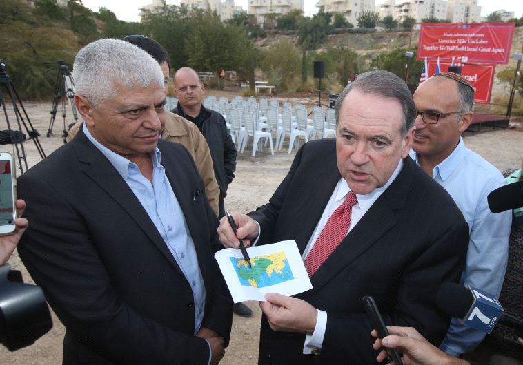 Mike Huckabee with Ma'ale Adumim mayor Beni Kashriel, pointing to Israel on a map of the world for journalists
