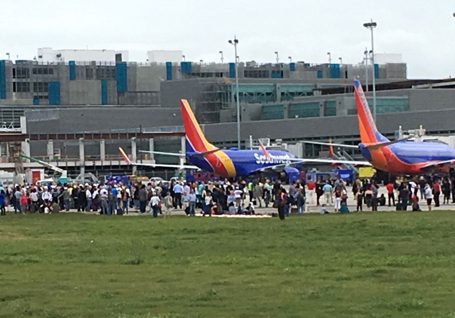Travelers are evacuated out of the terminal and onto the tarmac after a shooting at Fort Lauderdale-Hollywood International Airport