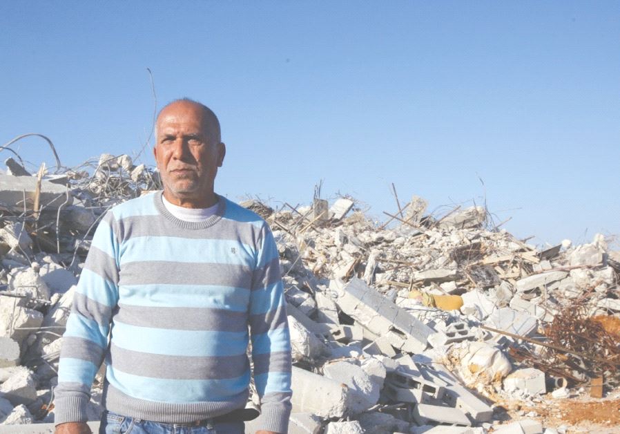 KALANSUWA RESIDENT Yusuf Makhlouf poses yesterday before the rubble of one of the 11 illegally built homes demolished by the government.