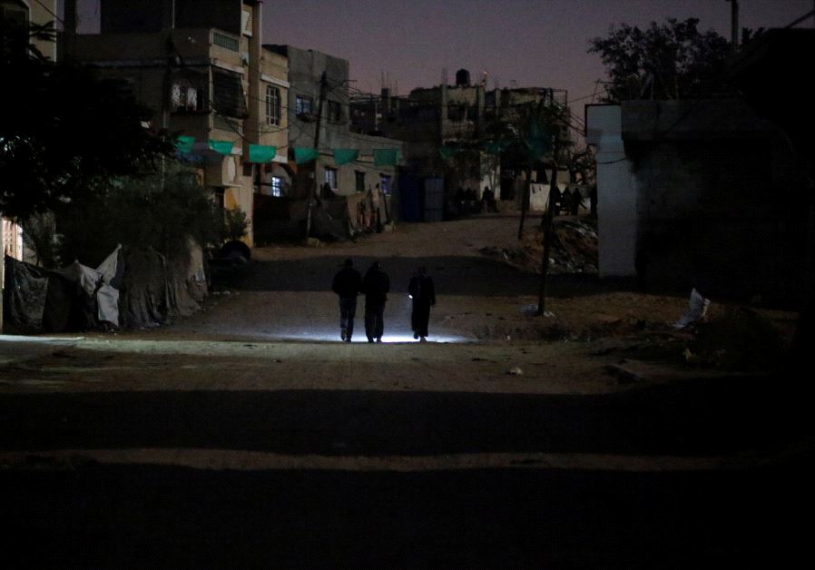 Palestinians walk on a road during a power cut in Beit Lahiya in the northern Gaza Strip.