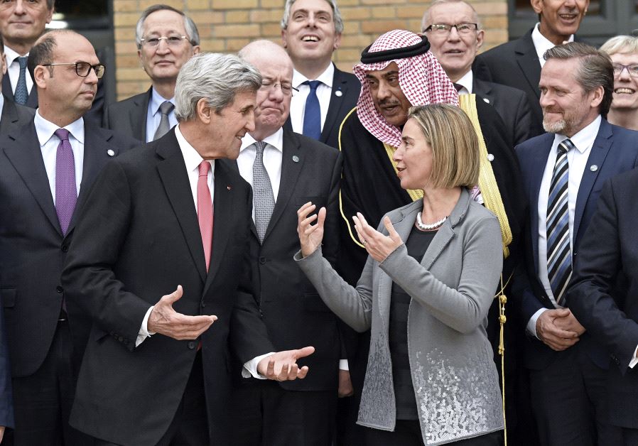 US Secretary of State John Kerry speaks with European Union Foreign Policy Chief Federica Mogherini as they take part with other foreign ministers and representatives in a family picture during the Mideast peace conference in Paris, France, January 15, 2017. 