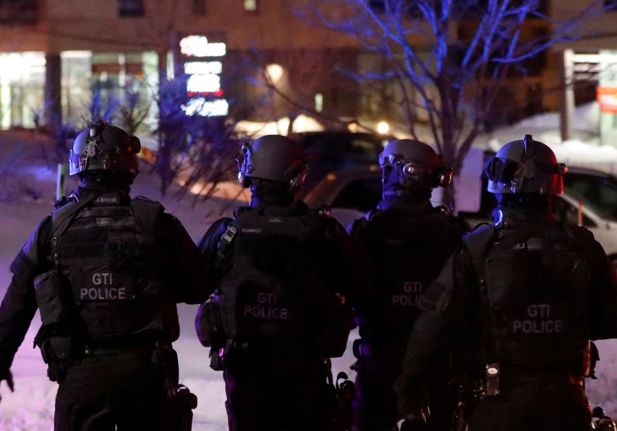 Swat team police officer walk aournd a mosque after a shooting in Quebec City, January 29, 2017. 