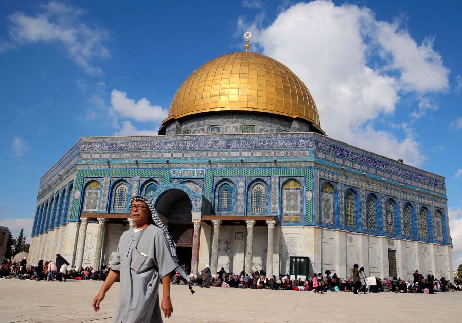 A man walks next to the Dome of the Rock on the Temple Mount compound 