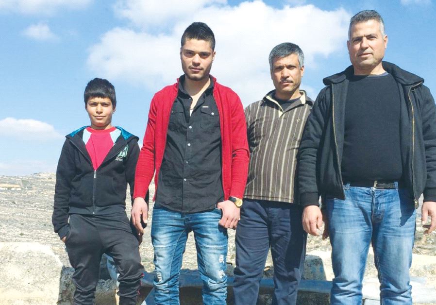 THE AL-AZZEH FAMILY stands yesterday near the ledge where the bus fell in Lubban Sharkiya, south of Nablus. From left: Mahdi al-Azzeh Samih al-Azzeh, Samir al-Azzeh and Jamal al-Azzeh