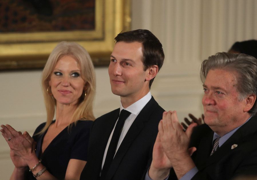Senior staff at the White House Kellyanne Conway, Jared Kushner and Steve Bannon (L-R) applaud before being sworn in by Vice President Mike Pence in Washington, DC January 22, 2017.
