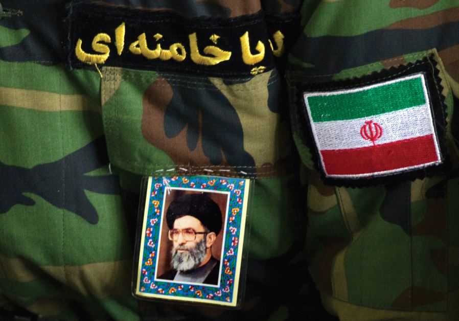 A MAN wearing an Iranian Revolutionary Guard uniform sports a portrait of Iran’s Supreme Leader Ayatollah Ali Khamenei.