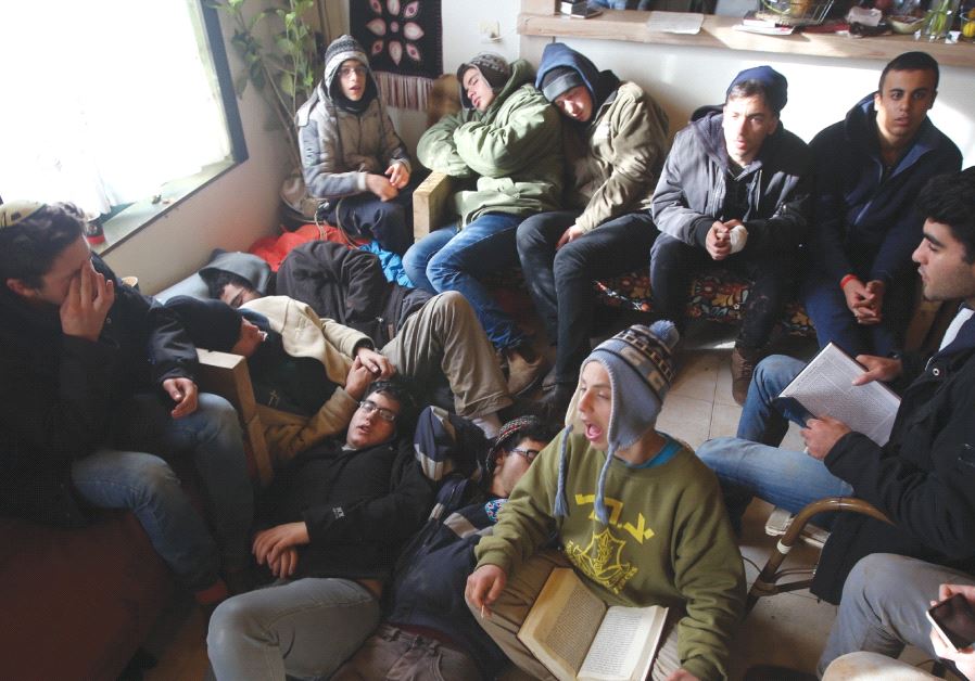 YOUNG PROTESTERS sit in a caravan singing and resting as they wait to be evacuated by police officers from the illegal outpost in Amona.
