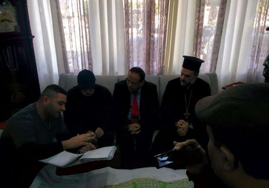Ala’a Kadado (left) showing Father Gabriel Naddaf and deputy minister Ayoub Kara the plans of the Shfaram neighborhood.