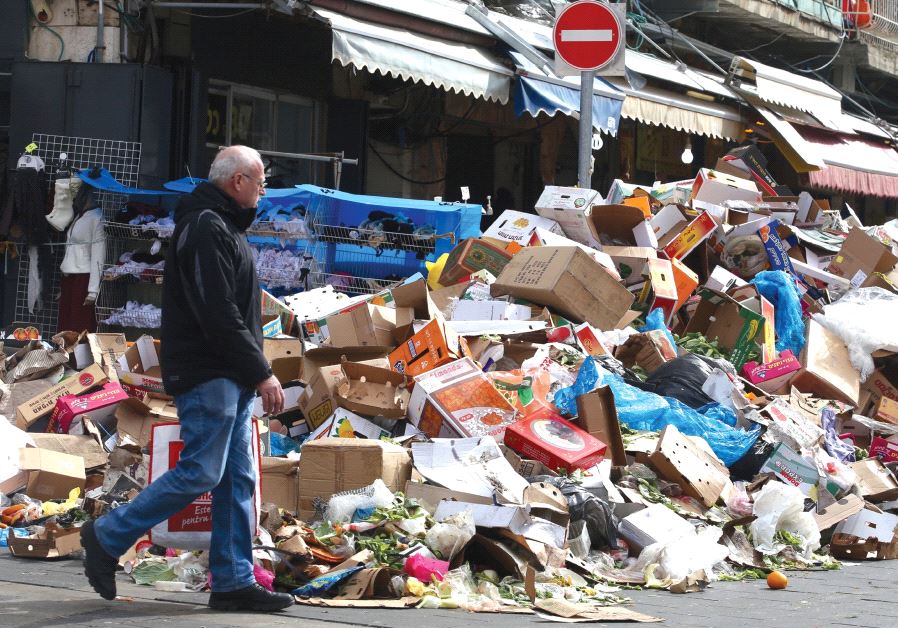 A MAN walks past a heap of garbage outside Jerusalem’s Mahaneh Yehuda Market during the three-day municipal strike that began on January 29.