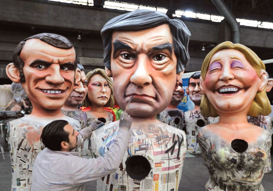 A WORKER puts the final touches on a figure of former French prime minister Francois Fillon, flanked by National Front leader Marine Le Pen and Emmanuel Macron, head of the political movement En Marche!, or Onwards!, during preparations for the carnival parade in Nice, France, earlier this month