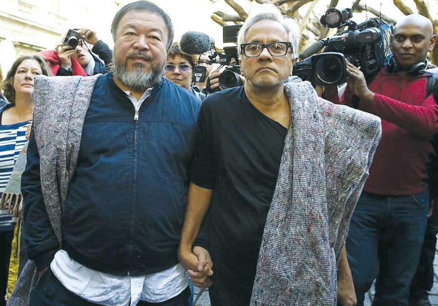 Artists Ai Weiwei (left) and Anish Kapoor carry blankets to symbolize the plight of refugees, as they walk through central London on September 17, 2015