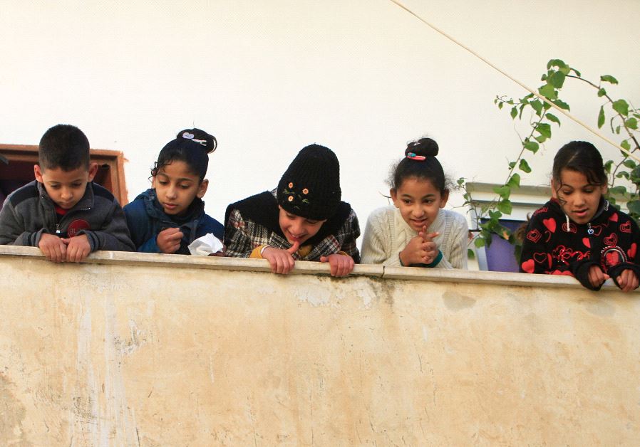 Children look out of the family house of Palestinian Mohammad Al-Salahe, 32, in Al-Faraa refugee camp near the West Bank city of Nablus