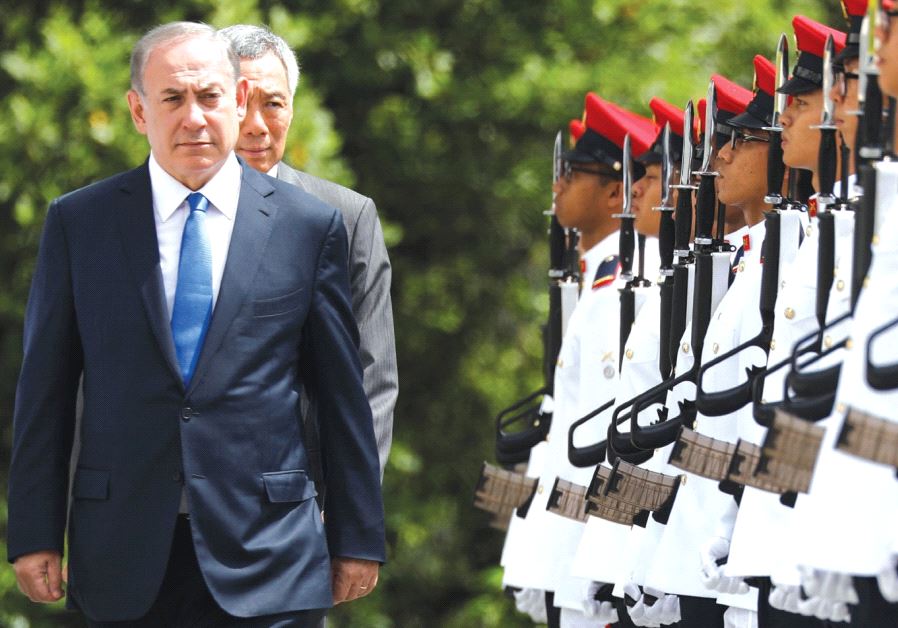 Prime Minister Benjamin Netanyahu inspects an honor guard with Singaporean Prime Minister Lee Hsien Loong at the Istana presidential palace in Singapore.