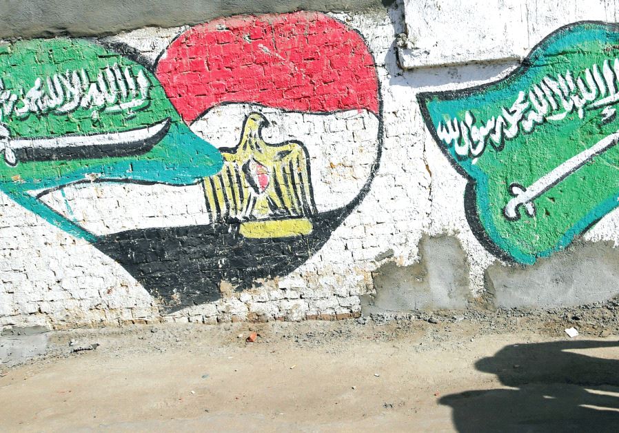 THE SHADOWS of men walking are seen in front of graffiti depicting relations between Egypt and Saudi Arabia in Cairo last year