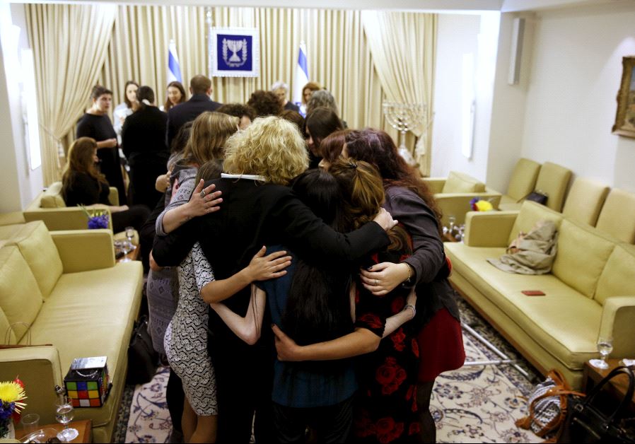 Women who took part in a project ahead of International Women's Day (marked on March 8), hug during a meeting with Nechama Rivlin (not pictured), wife of Israeli President Reuven Rivlin in JerusalemDay
