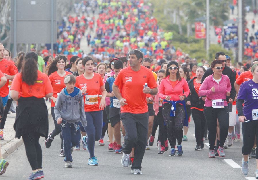 Runners in the 2016 Jerusalem Marathon jog uphill ahead of some 25,000 others who took part in the event