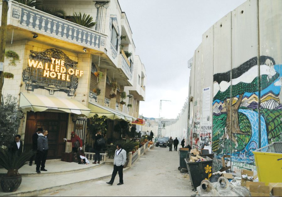 People stand outside the Walled Off Hotel, which was opened by street artist Banksy, in Bethlehem