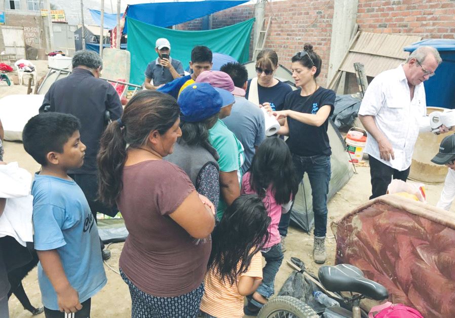 ISRAAID STAFF MEMBERS assist displaced residents in Lima last Friday.