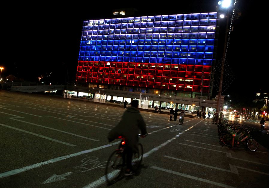 A man rides bicycle across the Tel Aviv city hall building as it is illuminated in solidarity with Russia after the blast in the St.Petersburg metro in Tel Aviv, Israel April 3, 2017